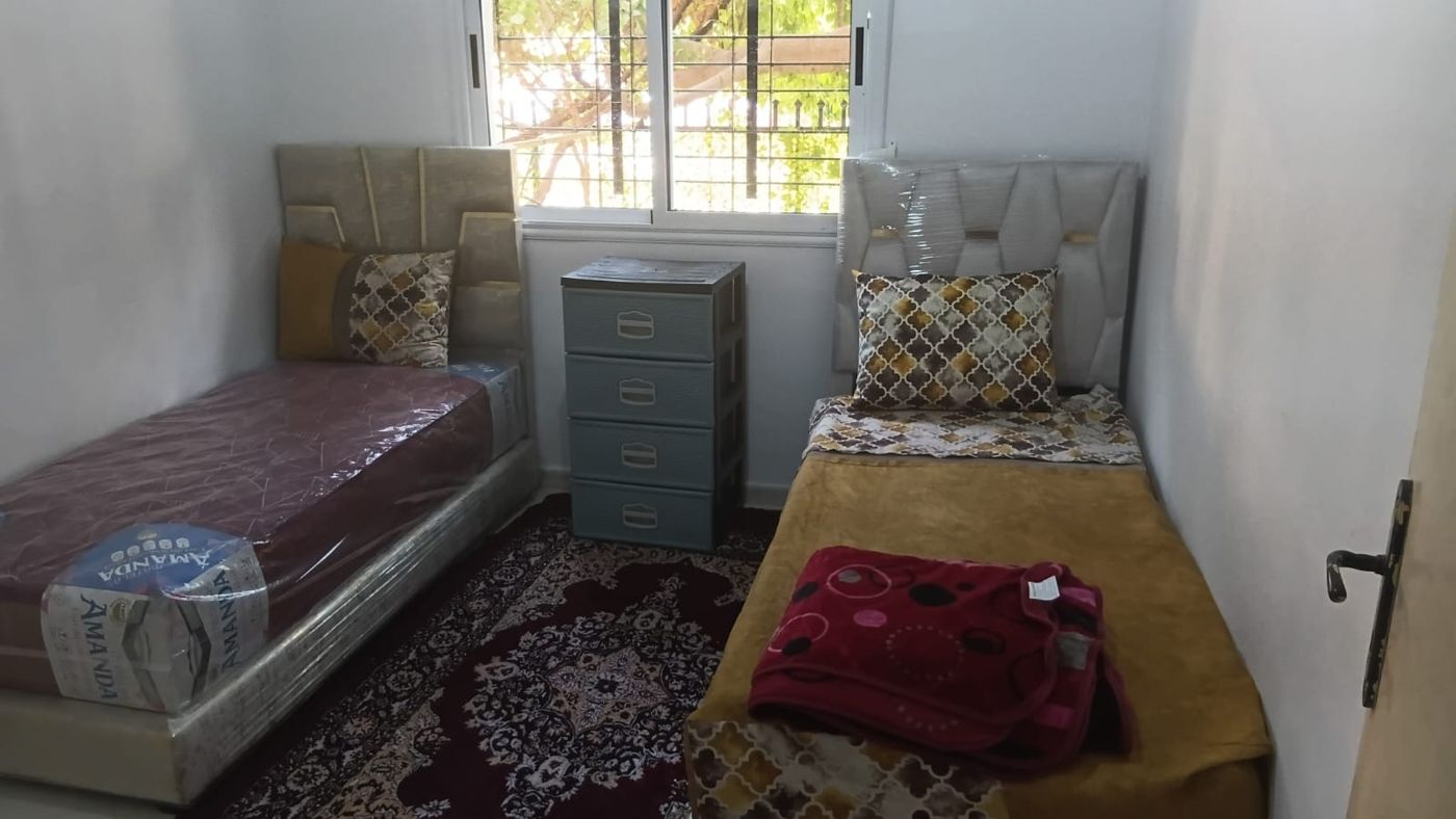 Chambre meublée avec deux lits individuels et commode